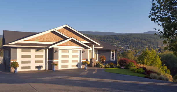 Front view of a new neat modern white low set single story family home with green grass and blue sky for copy space.