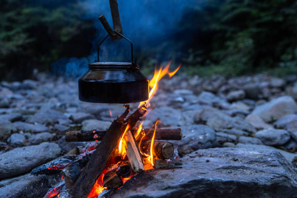The sun sets and a bonfire is fired on the riverside