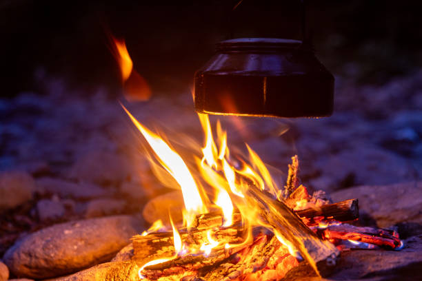 The sun sets and a bonfire is fired on the riverside