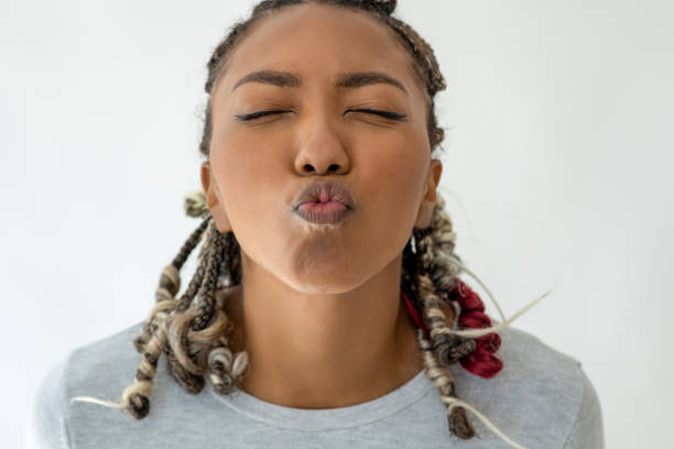 A calm young girl posing with closed eyes and a serene expression in a bright studio.