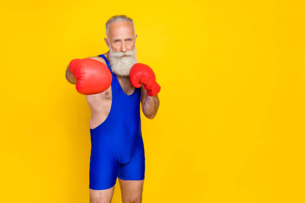 Full length photo old age pensioner wear red boxing gloves versus hit serious grandfather professional empty space ad new gym isolated on yellow color background Full length photo old age pensioner wear red boxing gloves versus hit serious grandfather professional empty space ad new gym isolated on yellow color background. athlete fails stock pictures, royalty-free photos & images