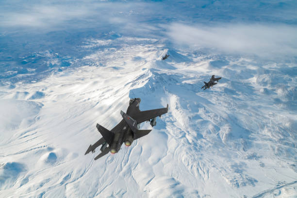 Jet fighters flying over snowcapped mountains.