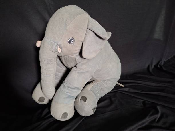istock A whimsical gray elephant toy stands out against a sleek black background, highlighting its plush texture and adorable features. Perfect for capturing the essence of childhood joy and imagination. 2173670793