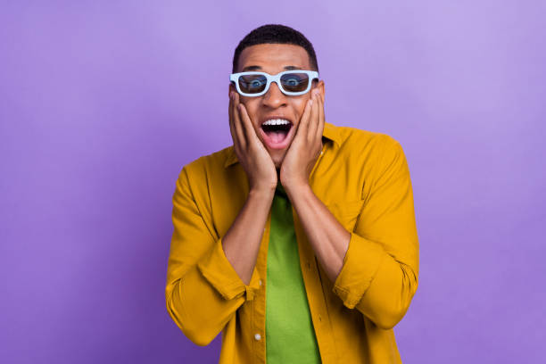 istock Photo of impressed speechless ecstatic guy dressed yellow shirt 3d glasses palms on cheekbones isolated on violet color background 2173675941