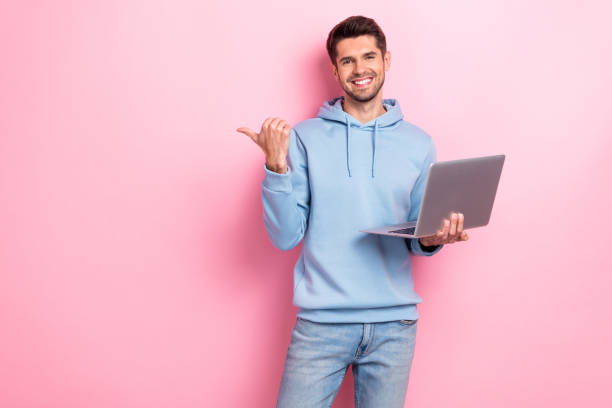 istock Photo of positive charming guy dressed blue sweatshirt typing modern gadget thumb empty space isolated pink color background 2173678951