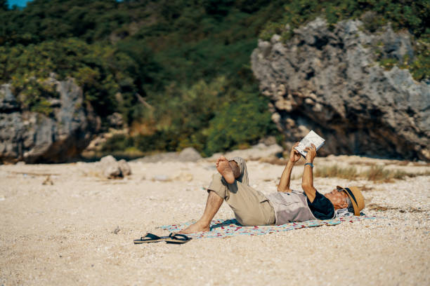 Little red coffee mug on the stacked books near the clear turquoise sea surface