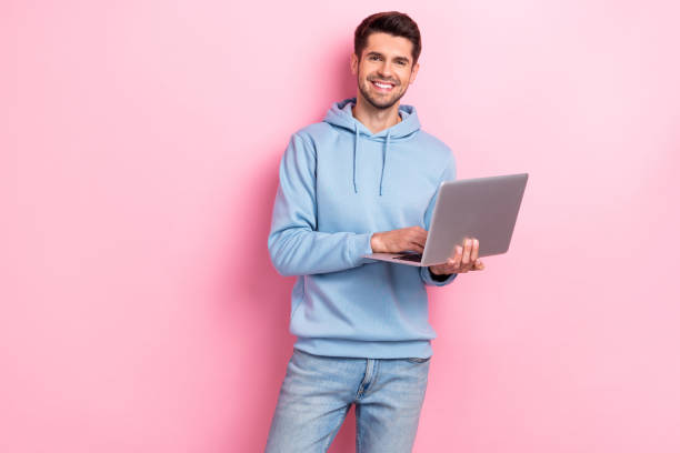 istock Photo of pretty positive guy dressed blue sweatshirt working apple samsung gadget empty space isolated pink color background 2173678954