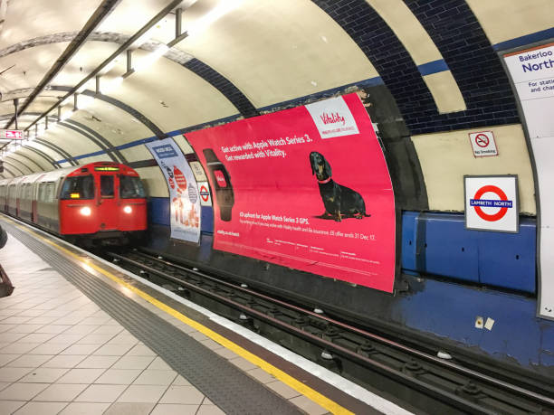 Curved platform at Lambeth North Station in London, showing tiled walls, roundel, safety line and empty tracks on the Bakerloo line. London, UK, 9 July 2023