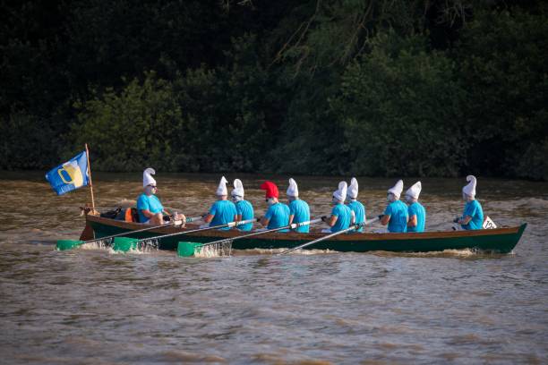 Hammersmith, United Kingdom - September 21, 2024: A crew dressed as Smurfs row on the River Thames during the Great River Race