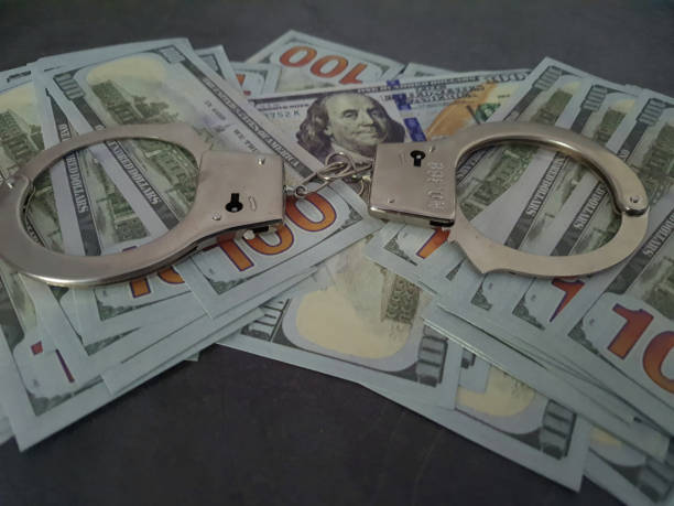 istock Handcuffs on the hundred-dollar bills. 2173696925