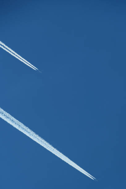 istock Airplane trail in the blue sky, parallel contrails 2173701327