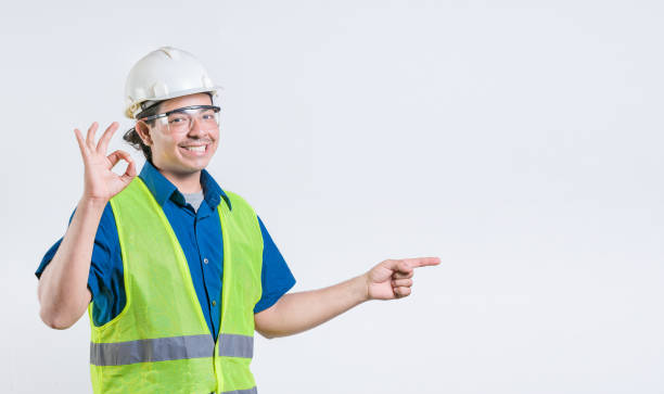istock Portrait of latin engineer recommending and pointing aside. Cheerful engineer pointing at promotion isolated 2173705112