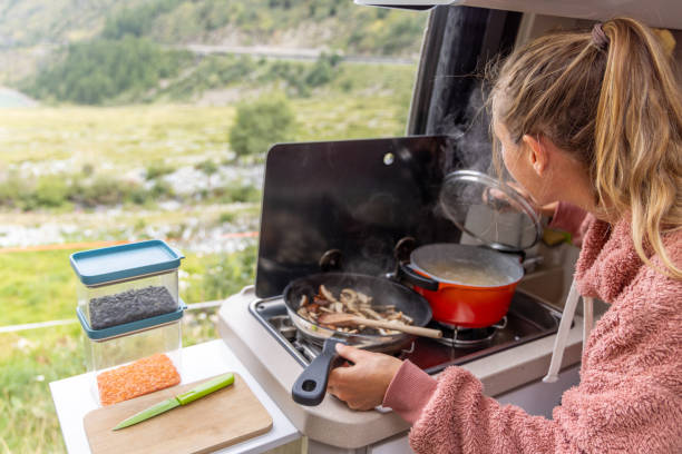 istock Woman Opening Pot While Cooking in Campervan Kitchen 2173706734