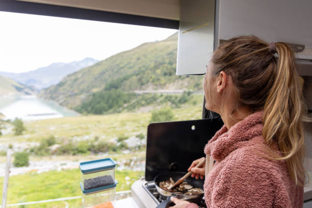 istock Woman Cooking in Campervan Kitchen While Traveling 2173706735