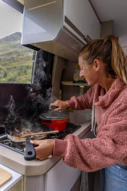 istock Woman Opening Pot While Cooking in Campervan Kitchen 2173706779