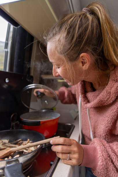 istock Woman Opening Pot While Cooking in Campervan Kitchen 2173706784