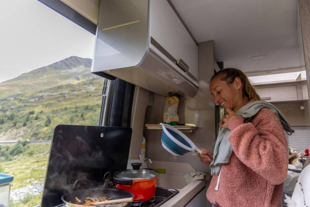 istock Woman Smiling While Holding Strainer in Campervan Kitchen 2173706789