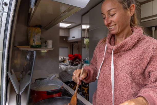 istock Smiling Woman Stirring Food in Campervan Kitchen 2173706813