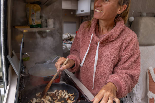 istock Smiling Woman Stirring Food in Campervan Kitchen 2173706814