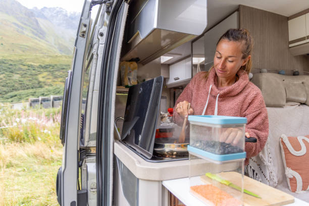 istock Smiling Woman Stirring Food in Campervan Kitchen 2173706817