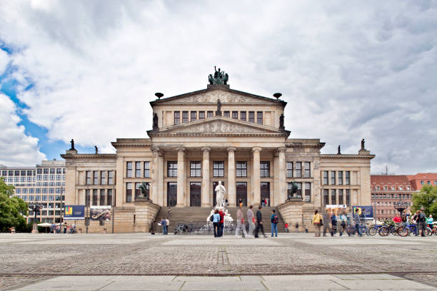 Berlin, Germany, July 24 2009, Tourists explore the stunning Konzerthaus at Gendarmenmarkt in Berlin, showcasing its impressive architecture under a cloudy sky.