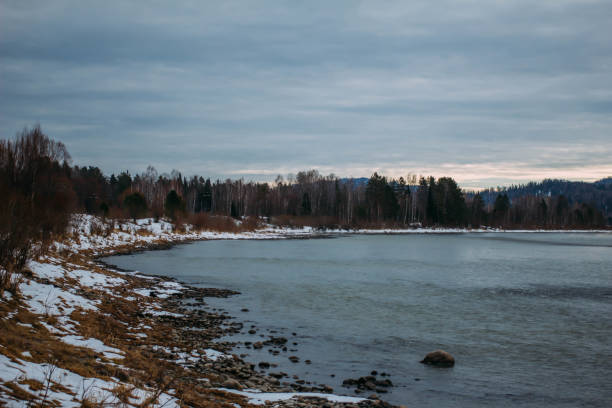 istock A mountain lake partially covered with ice, reflecting the surrounding forest. 2173713017
