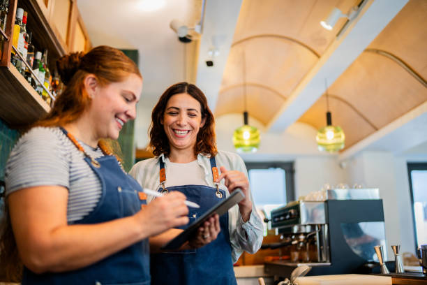 istock Coworkers talking and using digital tablet at coffee shop 2173720687