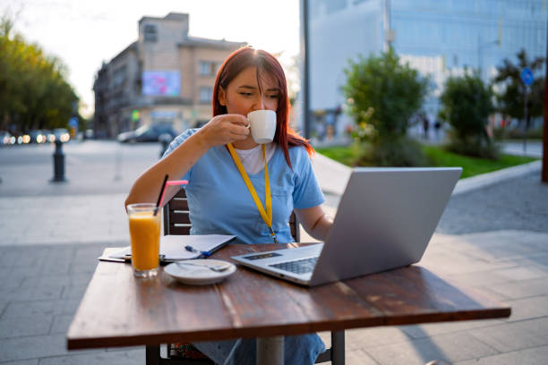 istock Person in scrubs enjoying a drink while working at cafe. 2173721444
