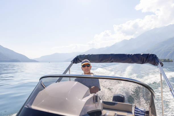 istock Man Driving a Speedboat on a Lake with Mountain Views 2173722853