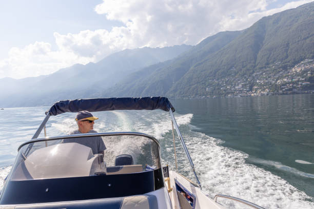 istock Man Driving a Speedboat on a Lake with Mountain Views 2173722880