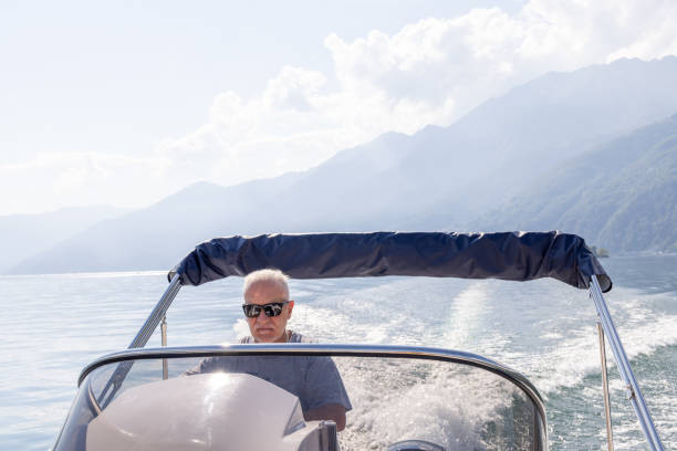 istock Man Steering Speedboat on a Lake with Mountain Backdrop 2173722887