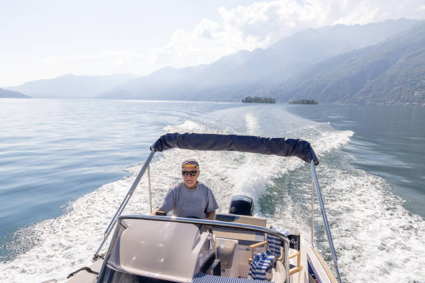 istock Man Steering Speedboat on a Lake with Mountain Backdrop 2173722930