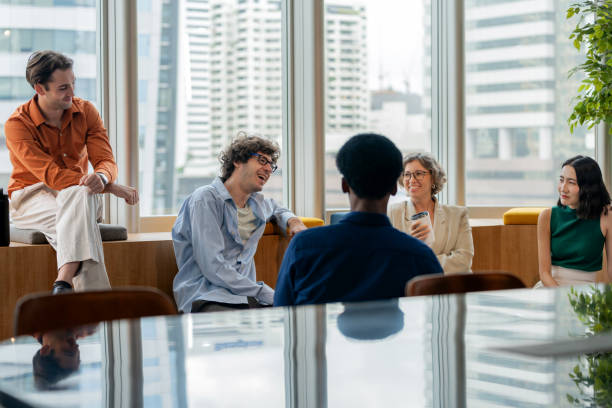 istock A diverse group of multi-ethnic employees take a break from work, happily chatting and engaging in conversation within a modern office setting. The atmosphere reflects a supportive and collaborative workplace where team members build camaraderie. 2173725883
