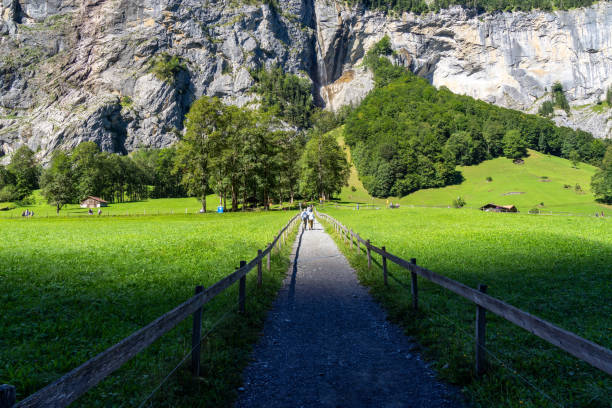 A beautiful valley village in Swiss Alps surrounded by dramatic cliffs and lush green meadows, Bernese Oberland, Switzerland