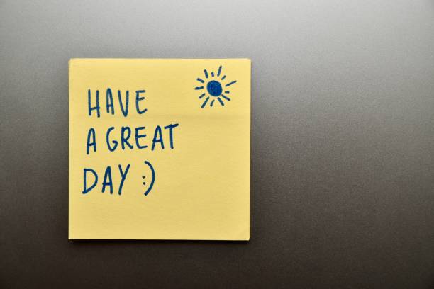 Good wishes written on a yellow Post-It on a desk. Motivational writing on sticky notes minimal concept