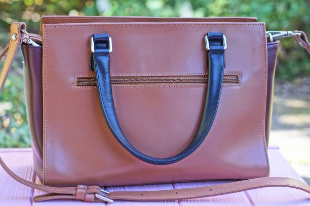 istock one big brown leather bag with black handle stands on pink table 2173745126