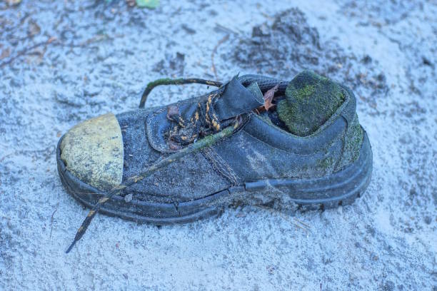 istock one old dirty leather black boot stands on the gray ground 2173746356