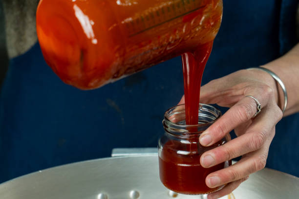 Pouring Homemade Rosehip Jam into a Jar