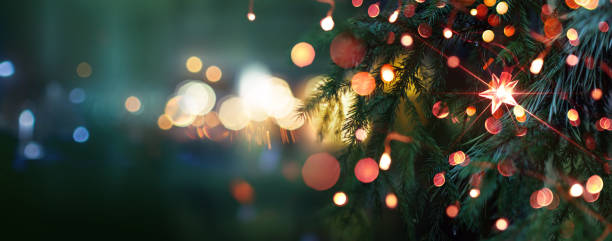Christmas tree with bright star. Evening city with blurred background