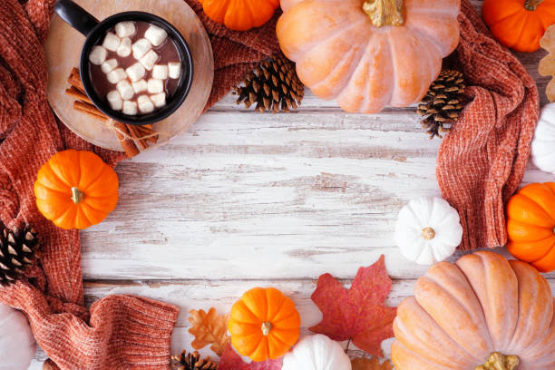 istock Cozy fall frame with pumpkins, sweaters and hot chocolate on a white wood background 2173752728