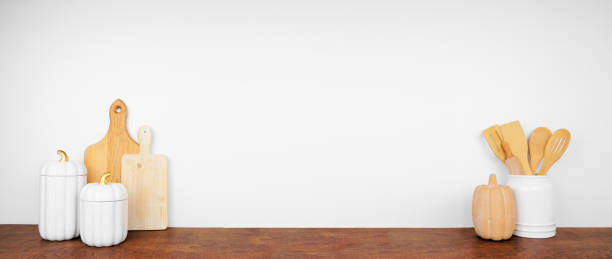 istock Fall kitchenware, utensils and decor on a wood shelf or counter against a white wall background 2173752833
