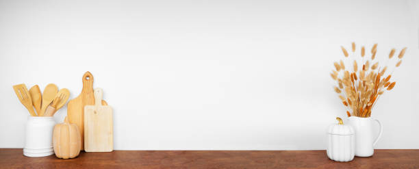 istock Autumn theme kitchenware, utensils and decor on a wood shelf or counter against a white wall background 2173752913