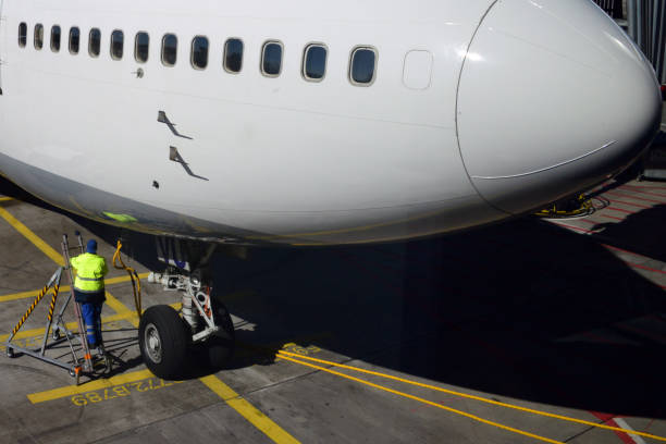 istock Worker placing ground power unit (GPU) cables on an aircraft 2173754380