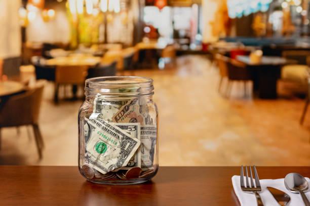 istock Tip jar in restaurant dining room. Service industry tipping, minimum wage and gratuity concept. 2173759988