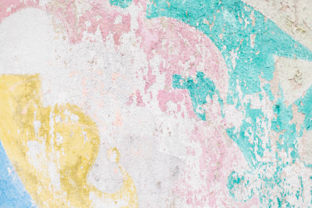 This is a closeup view of a beautifully weathered wall showcasing soft pastel colors and intriguing abstract patterns