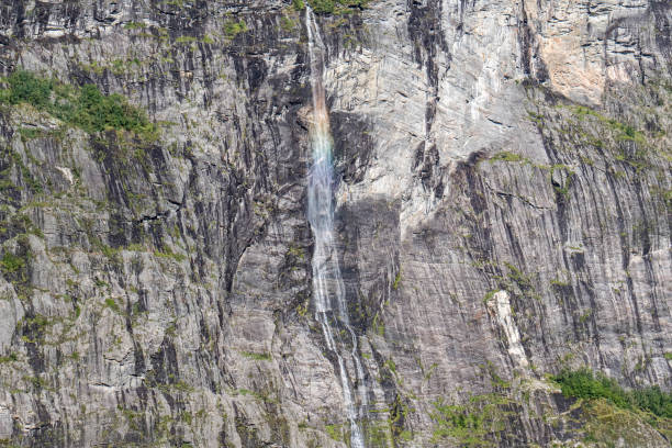 Kleiner Wasserfall mit Regenbogen im Geiranger Fjord