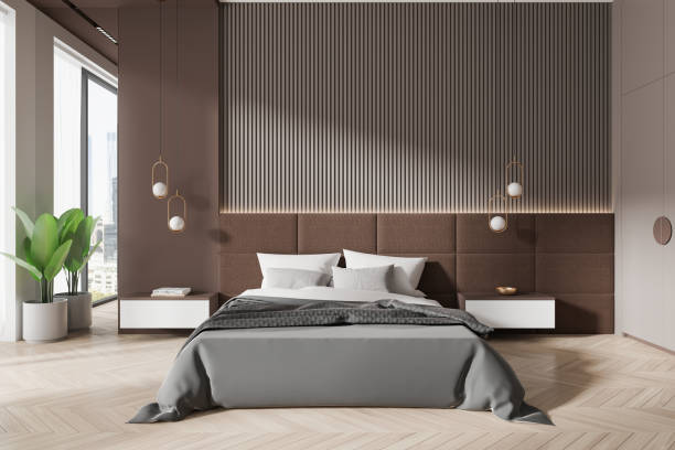 istock Modern bedroom with minimalist decor, featuring a stylish bed, sleek lighting, and a potted plant by large windows. Light-filled room with a luxurious, contemporary concept.  3D Rendering 2173778684