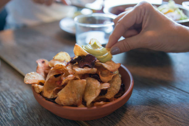 istock Unrecognizable woman hand picking chips from a bowl 2173784341