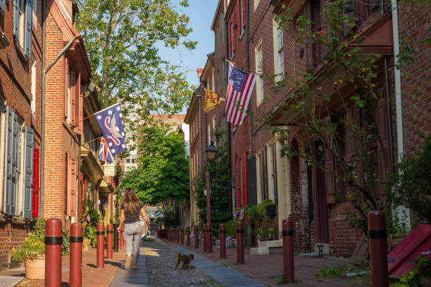 Philaderlphia, USA - July 28, 2024. A lady walking her dog at Elfreth's Alley, Philadelphia, Pennylvania, USA