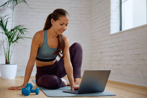 istock Happy athletic woman following online exercise class over laptop. 2173790346